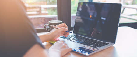 Business woman hand is using a laptop computer in office.On the table there is a credit card.Web...