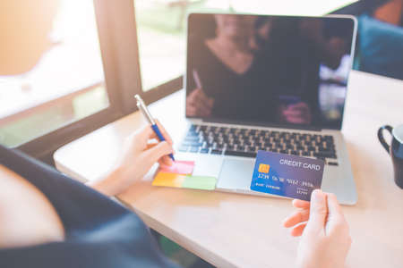 Business women use credit cards to shop online.