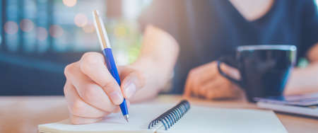Business woman hand is writing on a notepad with a pen.Web banner.の写真素材