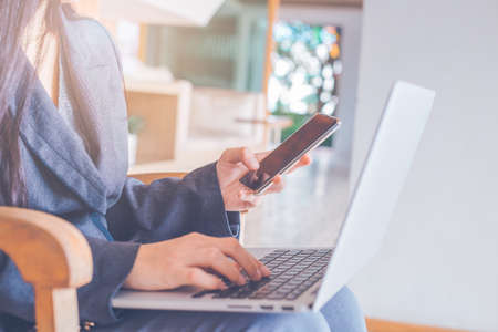 Business women hand use laptop computers and mobile phone
in office.の写真素材
