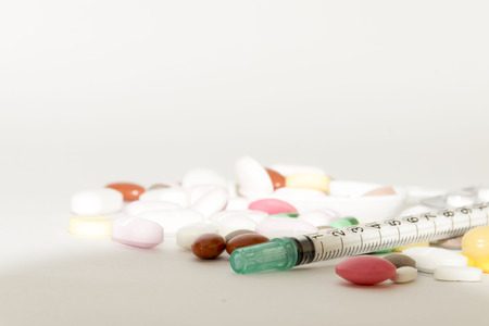 Syringe and assorted medical drugs, vitamin on white background with copy spaceの写真素材