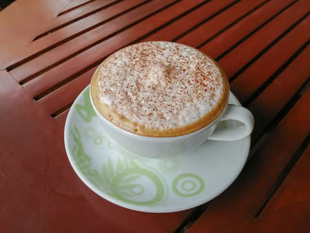 Coffee cup resting on a wooden tableの写真素材