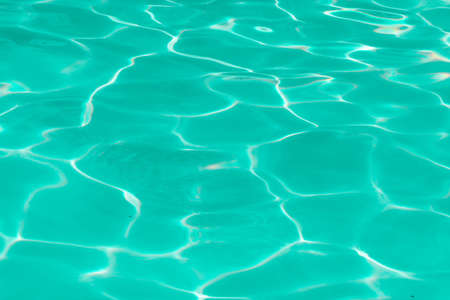 green pool water with sun reflections.