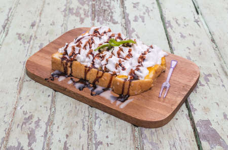 Toast cream is placed on a wooden table.の写真素材