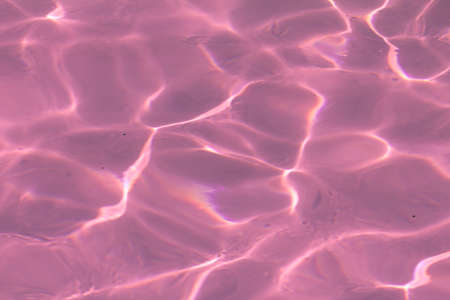 pink pool water with sun reflections.の写真素材