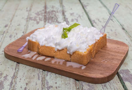 Toast cream is placed on a wooden table.の写真素材