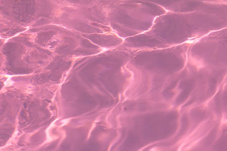 pink pool water with sun reflections.の写真素材