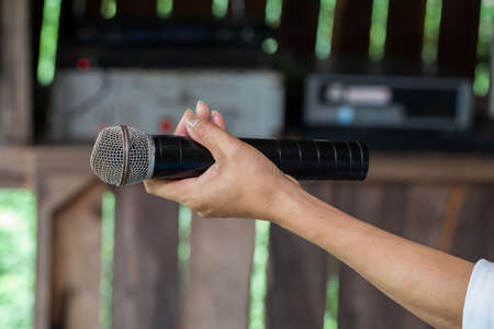Old black microphone in hand, combined with the party.の写真素材