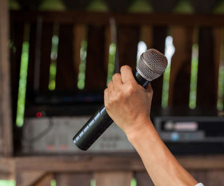 Old black microphone in hand, combined with the party.の写真素材