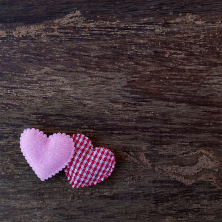 Two pink hearts placed on the old wooden floor