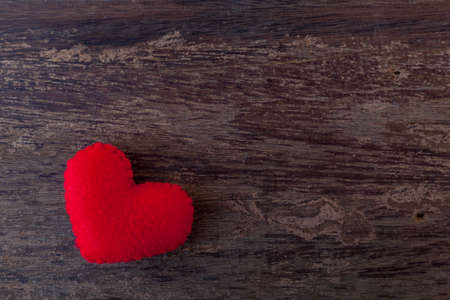 Red heart is placed on a wooden floorの写真素材