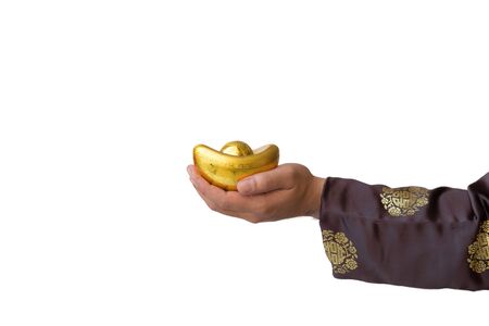 close up of man's hand hold the gold ingot who wear chinese dress to celebrate chinese new year isolated on white backgroundの写真素材