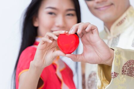 Close up of love symbol from the couple's hand of chinese man and woman isolate on white background.の写真素材