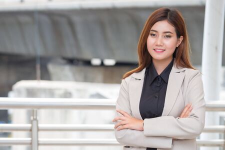 Beautiful smart Business woman with smileing face is crossing her arms in the city backgroundの写真素材