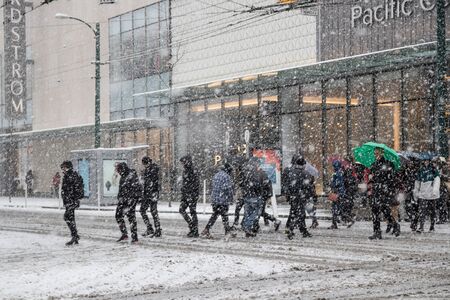 Vancouver, CANADA - 23 Feb, 2018 : People walk across the road while winter time with Snow storm in Downtown Vancouver, Canada Winter time with Snow storm in Downtown Vancouver, Canadaのeditorial素材