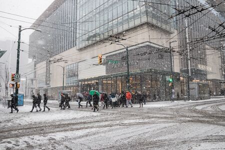 Vancouver, CANADA - 23 Feb, 2018 : People walk across the road while winter time with Snow storm in Downtown Vancouver, Canada Winter time with Snow storm in Downtown Vancouver, Canadaのeditorial素材