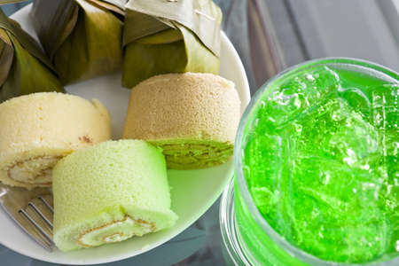 Thai desserts wrapped in banana leaves and steamed cooked with Bun stuffed with cream and aerated soft drinkの写真素材