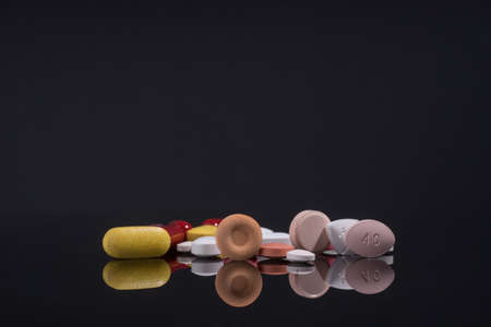 Medical pills on black background with reflection.の写真素材