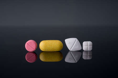 Medical pills with different shape size and color on black background with reflection.Studio Shot.の写真素材