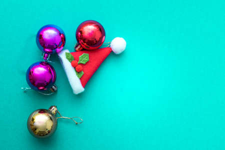 Christmas ornament balls and santa hat on green background.の写真素材