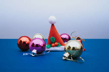 Christmas ornament balls and santa hat on grey background.の写真素材