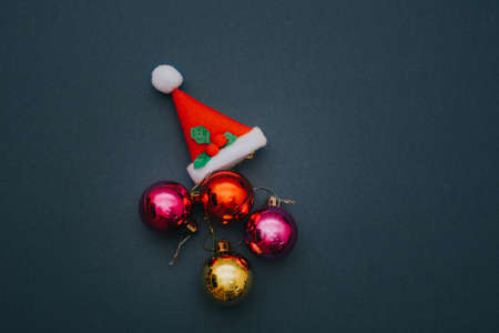 Christmas ornament balls and santa hat on grey background.の写真素材