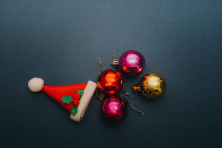 Christmas ornament balls and santa hat on grey background.の写真素材
