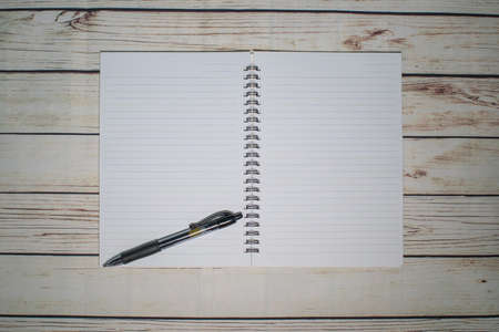 Pen and blank note paper on vintage wooden table.Background concept with copy space.