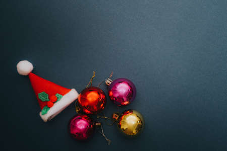 Christmas ornament balls and santa hat on grey background.の写真素材