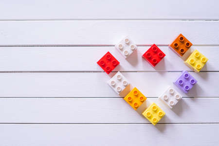 Colorful Kid's block toy forming a heart shape on white wooden table.Child education concept.の写真素材