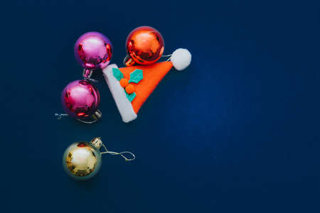 Christmas ornament balls and santa hat on grey background.の写真素材