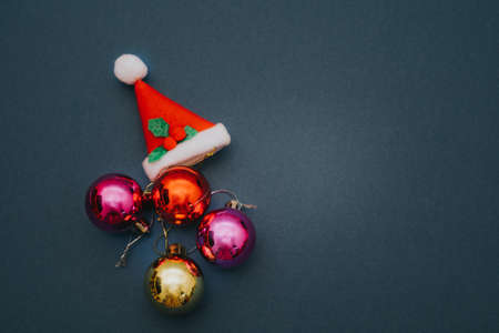 Christmas ornament balls and santa hat on grey background.の写真素材