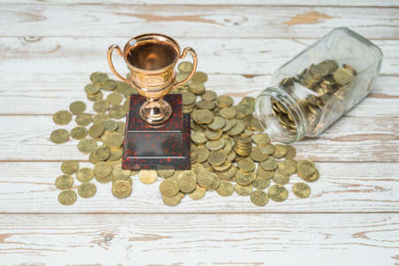 A golden trophy on beds of coins.の写真素材