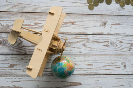Wooden Airplane toy with world globe on white background.Travel Concept.の写真素材