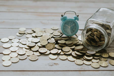 Alarm clock on bed of coins.
