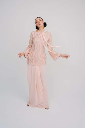 Beautiful female model wearing Asian traditional dress for Muslim woman isolated over white background.Eid ul fitr fashion and beauty.の写真素材