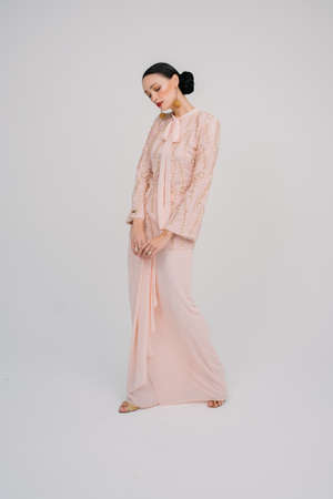 Beautiful female model wearing Asian traditional dress for Muslim woman isolated over white background.Eid ul fitr fashion and beauty.の写真素材