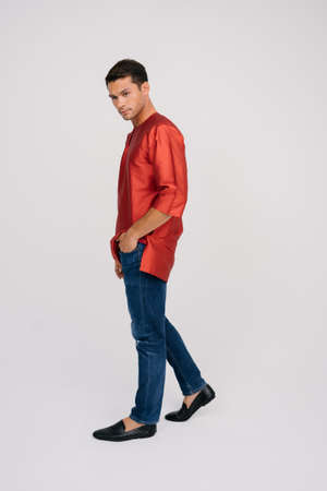 Handsome young Asian male wearing Baju Melayu isolated over white background.Modern fashion for Eid ul Fitr.の写真素材