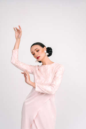 Beautiful girl wearing Asian Malay traditional dress isolate over white background.Modern female fashion for Eid al Fitr celebration or formal event.の写真素材