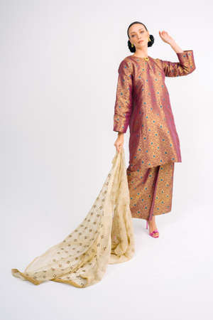 Beautiful female model wearing Asian Malay traditional dress and scarf isolated over white background.Fashion for Muslim Female.の写真素材