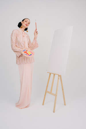 Beautiful female model wearing Asian traditional dress for Muslim woman isolated over white background. Eid al fitr fashion and beauty.の写真素材