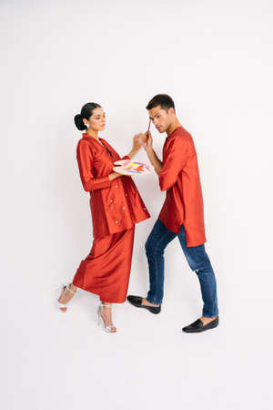 Happy couple wearing red traditional dress during Eid ul Fitr celebration isolated over white background.Beauty and Fashion shoot.の写真素材