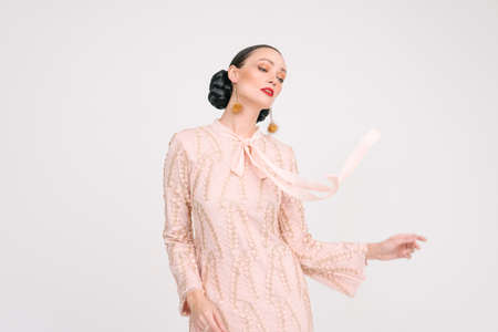 Beautiful girl wearing Asian Malay traditional dress isolate over white background. Modern female fashion for Eid al Fitr celebration or formal event.の写真素材