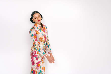 Beautiful girl wearing Baju Kurung (Asian Malay traditional dress) isolate over white background.Modern female fashion fro Eid Ul Fitr celebration or formal event.の写真素材