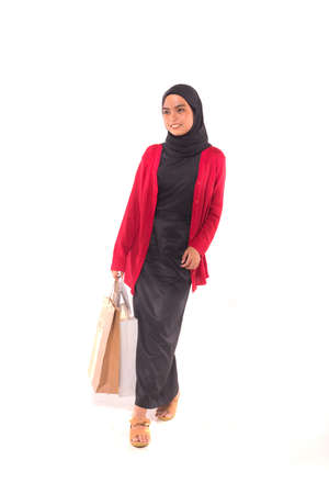Young female model holding shopping bag isolated over white background.の写真素材