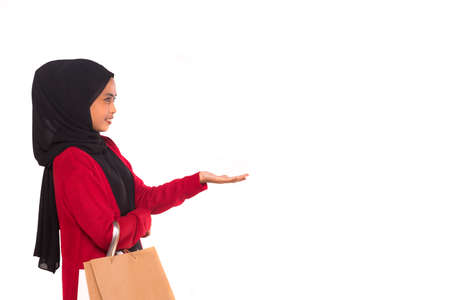 Young female model holding shopping bag isolated over white background.の写真素材