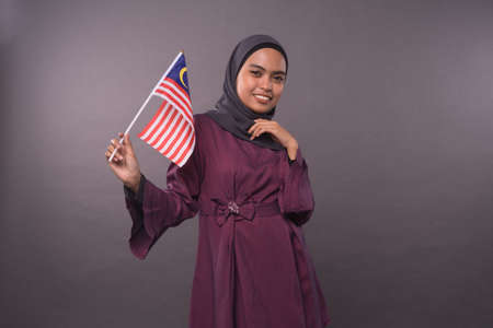 Happy Malaysian girl holding Malaysia Flag.Independence Day and patriotic concept.Studio shot.の写真素材