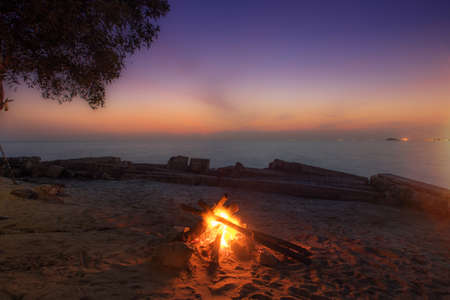 Camp fire by the beach during sunset.Amazing sunset view by the beach.の写真素材