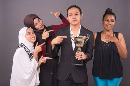 A group of professional worker holding a gold trophy and celebrating their victory.Business concept.の写真素材