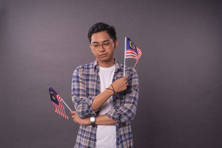 Malaysian teenager holding Malaysia Flag.Independence day and patriotic concept.Studio Shot.の写真素材